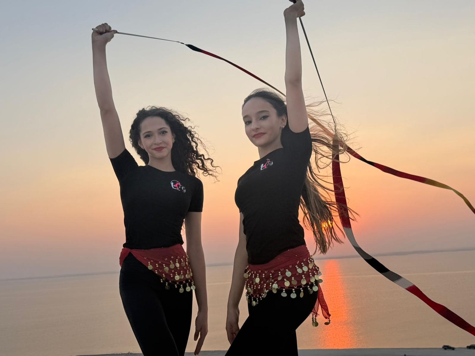 Queens Gymnastics athletes at sunset